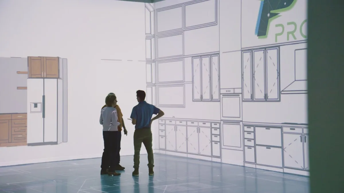 Wraparound wireframe projection across two studio walls with people standing inside it
